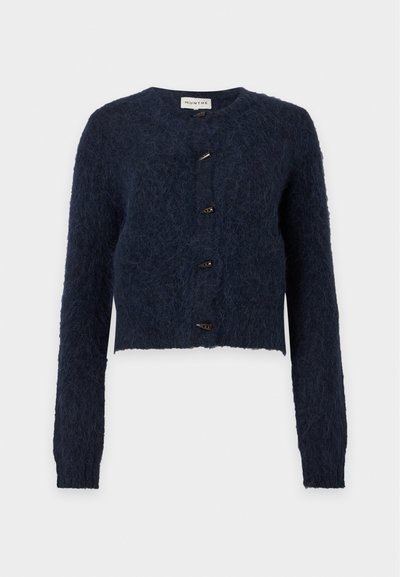 Cardigan en maille duveteuse bleu foncé avec manches longues, encolure ronde et quatre boutons à bascule noirs sur le devant.