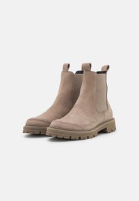 Stivali Chelsea in suede beige con pannelli elastici laterali, linguette di inserimento e suole in gomma spesse con un modello di battistrada robusto.