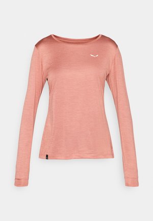 Långärmad skjorta i ljusrosa, tillverkad av mjukt tyg. Har en rundad halsringning och en liten vit logotyp på bröstet.