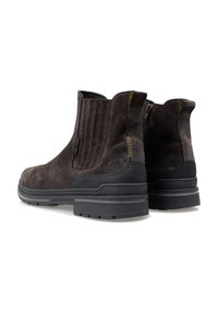 Donkerbruine suède enkellaarsjes met een gestructureerde afwerking, zij-elastieken en een zwarte rubberen zool voor stabiliteit en grip.