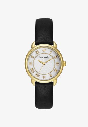 Rund gylden ur med sort læderrem, hvid urskive med romertal i guld og Kate Spade New York-logo.