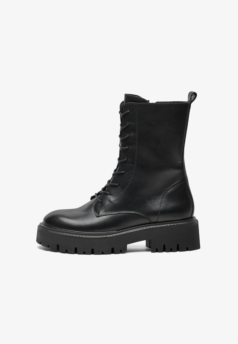 Svart lær lace-up militærstøvel med tykk såle, ankelhøy skaft og dragløkke bak på hvit bakgrunn.