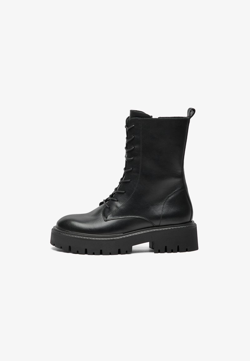 Svart lær lace-up militærstøvel med tykk såle, ankelhøy skaft og dragløkke bak på hvit bakgrunn.