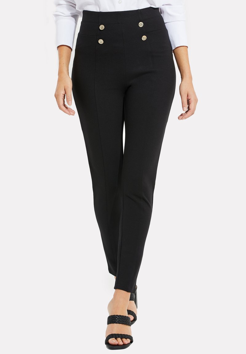 Hoge taille zwarte broek met een op maat gemaakte pasvorm, voorzien van twee goudkleurige knopen, zijnaad en een gladde textuur. Draagt met zwarte hoge hakken.