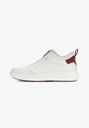 Zapatilla blanca de cuero suave con un panel texturizado, que presenta un acento marrón en el talón y una suela de goma con un patrón de tracción.