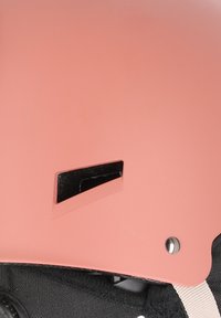 Rosa hjälm med matt yta, rektangulärt ventilationsutskärning, svart inredning och justerbart band med metallspänne.