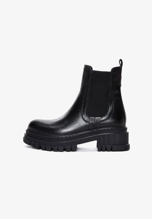 Des bottes Chelsea noires en cuir sont dotées de panneaux latéraux élastiques, d'une languette et d'une semelle en caoutchouc épaisse et texturée pour une meilleure adhérence et stabilité.