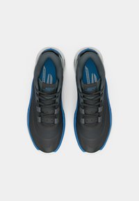 Chaussures de sport avec un design noir et bleu, dotées d'une texture lisse, d'un système de laçage et d'une semelle rembourrée. Étiquetées « BASKETBALL ». 