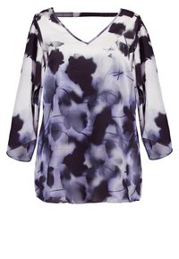 Blusa floreale viola con scollo a V, maniche 3/4 e un tessuto leggero e trasparente. Presenta un motivo ad acquerello in diverse tonalità di viola.