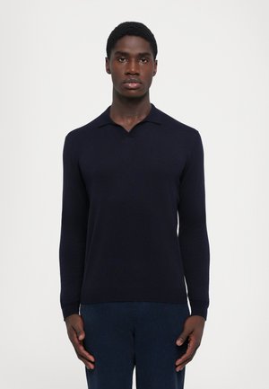 Navy long-sleeve polo shirt with a subtle texture and a classic collar, paired with dark-toned trousers. Simple and minimalistic design.