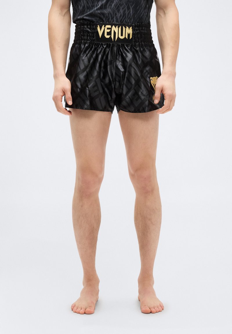 Μαύρο αθλητικό σορτς με γυαλιστερό φινίρισμα, υφή υφάσματος, λογότυπο VENUM σε χρυσό στη μέση και γραφικό λιονταριού στο τελείωμα.