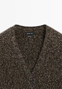 Donkerbruin en beige gebreid cardigan met een V-hals en een enkele zwarte knoop, gelabeld als 100% kasjmier door Massimo Dutti.