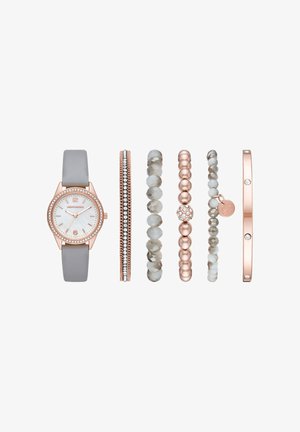 Roségouden horloge met een grijze leren band, omlijst door vijf armbanden met kralen en strass in grijs en roségoud.