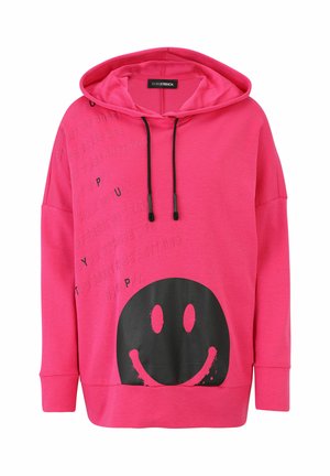 Helle rosa Kapuzenjacke mit schwarzen Kordeln, schwarzem Smiley-Gesicht-Graphic auf der Vorderseite und schwach eingeprägtem positiven Text auf der oberen linken Seite.