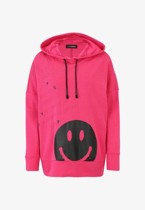 Helle rosa Kapuzenjacke mit schwarzen Kordeln, schwarzem Smiley-Gesicht-Graphic auf der Vorderseite und schwach eingeprägtem positiven Text auf der oberen linken Seite.