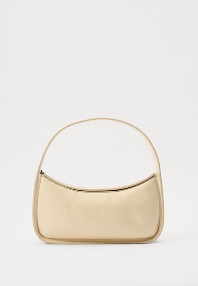 Geantă de umăr din piele bej, cu o textură netedă, formă curbată, un singur mâner superior și închidere cu fermoar pe marginea superioară. Design minimalist.