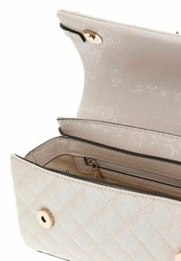 Helle beige, gesteppte Handtasche mit goldenen Beschlägen. Das Innere verfügt über eine Reißverschlusstasche und ein glattes Futter, das ein elegantes Musterdetail zeigt.