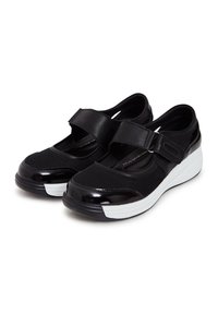 Chaussures noires avec un dessus en maille et en cuir laqué, dotées d'une large sangle Velcro, d'un embout rond et d'une semelle intermédiaire blanche. Détail de surface texturé.
