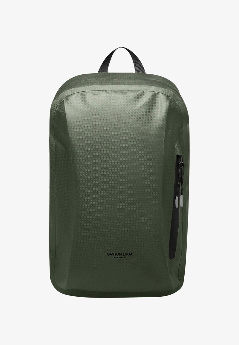 Zöld hátizsák, amely texturált nylonból készült, tetején fogantyúval és oldalsó cipzáras zsebbel rendelkezik. A márka logója a elülső részen van nyomtatva.