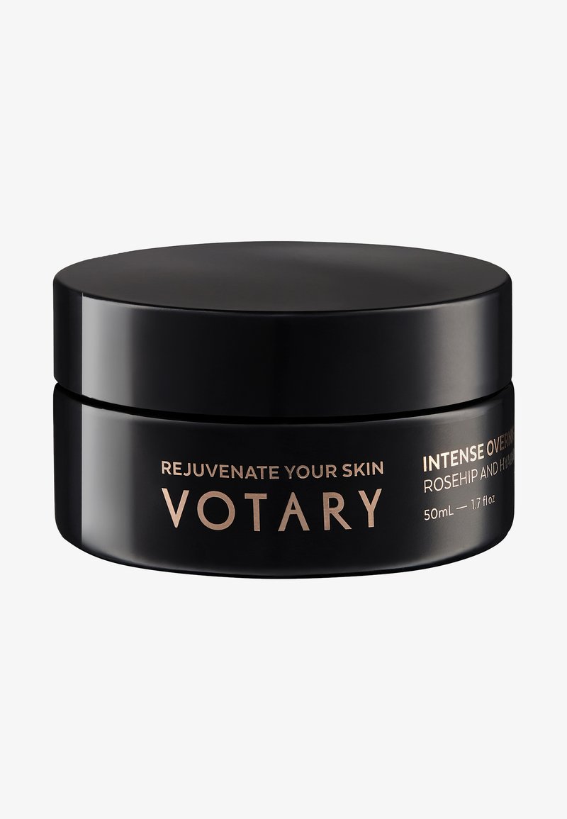 Zwarte ronde pot met een gladde matte afwerking en een strakke deksel. Gouden tekst toont productnaam en details. Capaciteit: 50 ml.