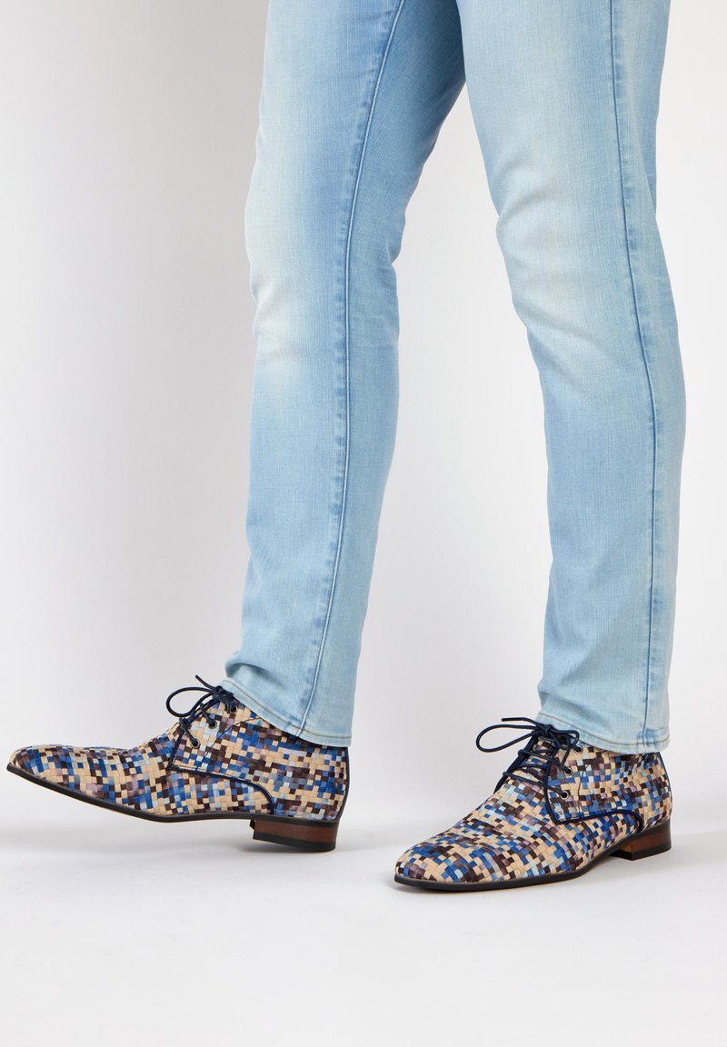 Kleurrijke gegoten dresschoenen met een mix van blauwe, beige en bruine vierkanten, een gladde textuur en een lage hak. Zwarte veters inbegrepen.