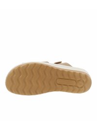 Sole in cuoio marrone con texture a onda, con intersuola bianca e dettaglio del logo. Materiale in gomma leggera per aderenza e durata.