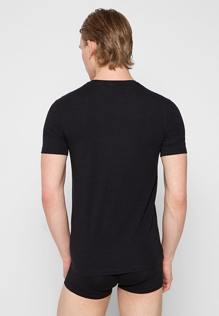 Camiseta negra de manga corta hecha de un material suave y elástico. Diseño sencillo con cuello redondo y forma ajustada.