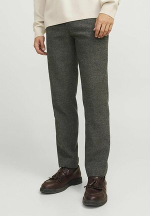 Graue, gewebte Hose mit strukturierter Oberfläche, taillierte Passform, seitliche Taschen, getragen mit dunkelbraunen Lederschuhen, die einen Kontrast bieten.