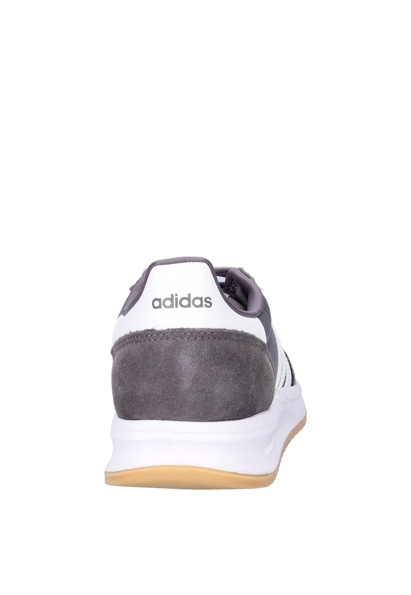 Grijze en witte Adidas-sneakers met een suède bovenwerk, rubberen zool en gestructureerde accenten. Het merklogo is zichtbaar op de hiel.