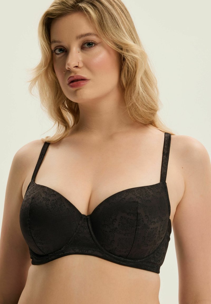 Czarny biustonosz balkonowy z gładkimi, wyściełanymi miseczkami, delikatnym, tonowym wzorem kwiatowym, regulowanymi ramiączkami oraz bezszwowym, zaokrąglonym kształtem.