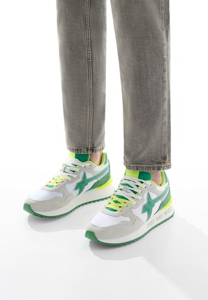 Sneaker con un design bianco e verde, dotati di una tomaia in suede e mesh, accenti neon, suola testurizzata e dettaglio "JUST SAY WIZZ" sul lato.
