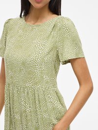 Abito a maniche corte in tessuto verde chiaro con motivo a pois bianchi. Presenta un collo rotondo e una vita arricciata per una vestibilità comoda.