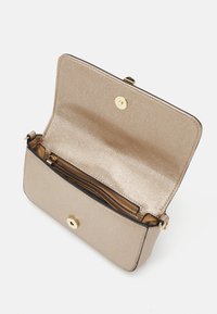 Bolso cruzado metálico dorado con un acabado texturizado, que presenta un cierre de imán, un bolsillo con cremallera en el interior y acentos de hardware en tono dorado.