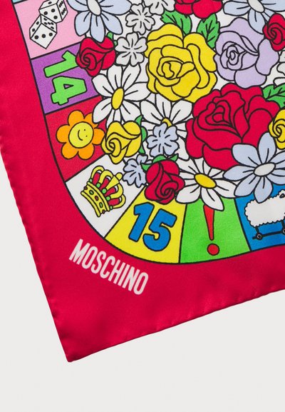 Rød silkescarf med et farverigt blomster- og brætspildesign, der indeholder tal, terninger og en krone; mærket med "Moschino" i hvid.