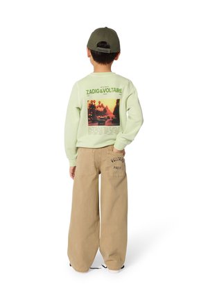 Sweat-shirt vert menthe avec un imprimé graphique dans le dos, associé à un pantalon large beige avec un logo sur la poche arrière.