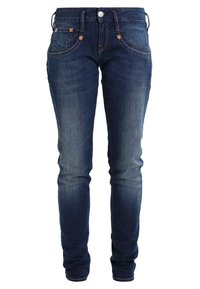 Jeans skinny in denim blu scuro con una finitura leggermente sbiadita, dotati di cinque tasche, rivetti in rame e chiusura con cerniera.