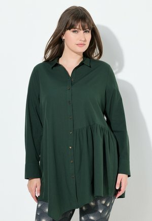 Camisa de botones verde oscuro con un dobladillo con pliegues, mangas largas y cuello; cuenta con botones dorados y un ajuste ligeramente holgado.