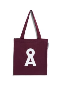 Bordeaux canvas draagtas met twee lange handvatten. Heeft een groot wit grafisch ontwerp dat lijkt op de letter "A" aan de voorkant.