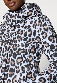 Giacca con stampa leopardata in bianco, nero e beige, con cappuccio, coulisse e patch logo sulla spalla. Tessuto liscio e strutturato.