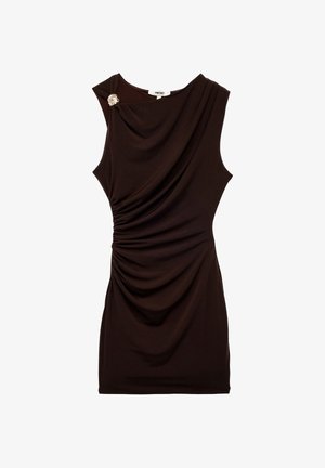 Bruine mouwloze jurk met gedrapeerd materiaal en geraffineerde details, voorzien van een decoratieve broche op de schouder. Soepele, zachte textuur.