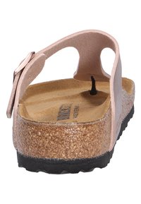 Sandal rosa con una soletta in sughero, finitura naturale testurizzata e suola in gomma nera; presenta una cinghia posteriore e ritagli laterali per la traspirabilità.