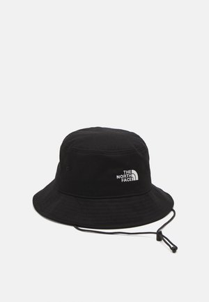 Czarny kapelusz typu bucket z regulowanym sznurkiem pod brodą i białym logo The North Face z przodu na jasnym, jednolitym tle.