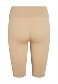 Pantalones cortos elásticos beige con una cinturilla alta acanalada, textura suave y forma ajustada. Longitud hasta el muslo con un diseño sin costuras.
