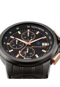 Zwarte zonne-energie horloge met een stalen kast en zwarte band. Heeft roségouden accenten, een tachymeter en meerdere chronografische sub-dials.