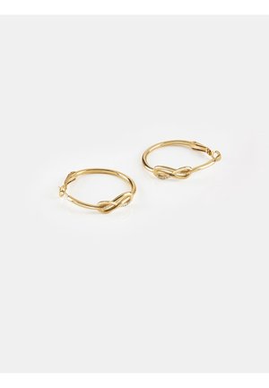 Par af gyldne hoops-øreringe med twist-design og små indlejrede klare sten på en hvid baggrund.