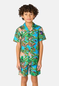 Conjunto de camiseta de manga corta y pantalones cortos, con un patrón de paisaje pixelado colorido en verdes, azules y marrones, hecho de tejido ligero.