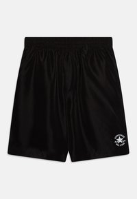 Shorts de sport noirs en tissu lisse, dotés d'une taille élastique et d'un logo blanc Converse All Star sur le bas de la jambe gauche.