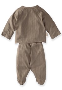 Ribbad, beige tvådelad outfit med långa ärmar och byxor med elastiska muddar, tillverkad av mjukt tyg för komfort.