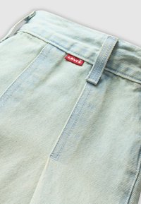 Jeans in denim azzurro chiaro con vita alta, caratterizzati da un'etichetta rossa Levi's sul retro e dettagli di cucitura visibili lungo le tasche e le cuciture.