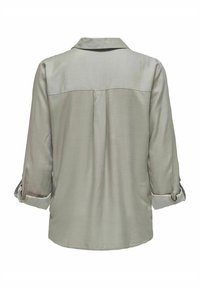 Camisa de manga larga verde claro con cuello, mangas enrolladas y una textura suave. La parte posterior presenta un canesú y detalles de pliegue central.